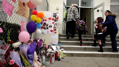 Estudiantes y padres miran el altar colocado en memoria de Joanna Ramos en la primaria de Long Beach.