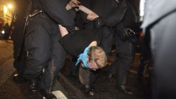 Agentes de policía detienen a un manifestante durante el desalojo del campamento 
de indignados frente a la catedral de San Pablo, en el este de Londres.
