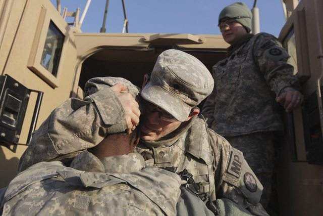 Soldados de la  Primera División de Caballería del ejército de EEUU se abrazan mientras se preparan para partir de la base Camp Ader.