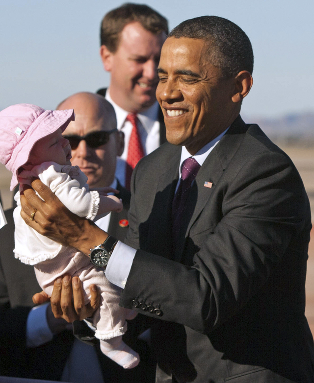 El presidente Barack Obama sostiene a una bebé  de dos meses  a su arribo a Air Force One en Mesa, Arizona, en enero.