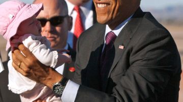 El presidente Barack Obama sostiene a una bebé  de dos meses  a su arribo a Air Force One en Mesa, Arizona, en enero.