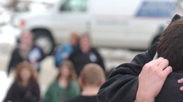 Un padre abraza a su hijo frente a la escuela   secundaria de Chardon, donde ocurrió  el tiroteo donde murieron 3 alumnos.