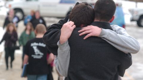 Un padre abraza a su hijo frente a la escuela secundaria de Chardon, donde ocurrió el tiroteo donde murieron 3 alumnos.