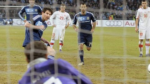 Lionel Messi (izq.) anota su tercer gol, éste de penalti, ante el guardameta de Suiza, Marco Woelfli, en la cancha del Stade de Suisse de Berna en el duelo amistoso dentro de la Fecha FIFA.