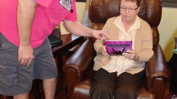 David Sachet, presidente de Rock Pink, muestra cómo usar el iPad a una paciente de cáncer.