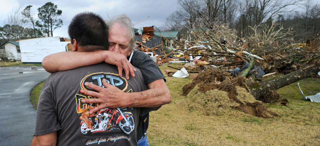 Dos víctimas se abrazan al evidenciar los estragos  que causaron los fenómenos meteorológicos en su paso por el estado de Alabama.