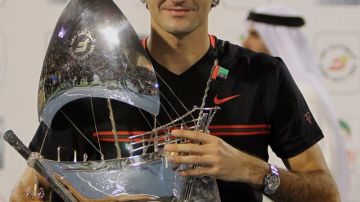 Federer sostiene y presume su trofeo ante su fanaticada.