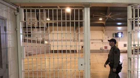 Un guardia atraviesa el gimnasio vacío de la prisión Deuel Vocational Institution de Tracy, donde una vez hubo hasta 700 camas.