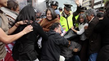 Un grupo de manifestantes se enfrentan con la policía durante una protesta al frente de la embajada de China en Quito (Ecuador).