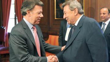 El mandatario colombiano, Juan Manuel Santos (i), estrechando la mano del canciller peruano, Rafael Roncagliolo.