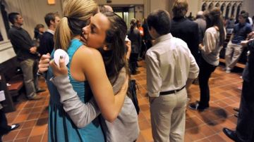 Las estudiantes de la Escuela Episcopal de Jacksonville Mary DeLorenzo, de 12 años (der.), y Laura Hacker, se abrazan luego de un servicio religioso para recordar a la víctima.