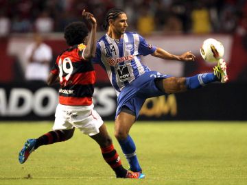 Negueba, jugador del Flamengo  (izq.),  marca a Fernando Giménez, del Emelec de Ecuador, en un pasaje del partido de  ayer jugado en Brasil.