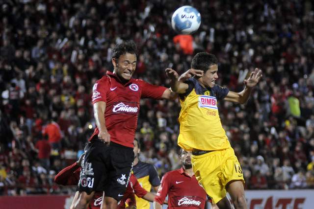 Juan Pablo Santiago (21) y Diego Reyes  pelean por alto el esférico  en la cancha del Estadio Caliente en el juego de anoche en Tijuana.