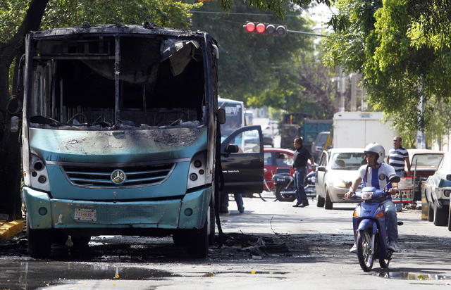 Uno de los 25 vehículos incendiados ayer durante varios bloqueos viales realizados  por grupos delictivos en Jalisco.