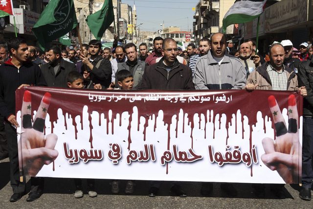 Seguidores del Frente de Acción Islámica muestran una pancarta en la que se lee 'Fin al baño de sangre en Siria', en Ammán, Jordania.