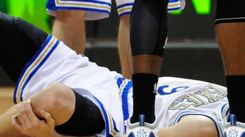 Ricky Rubio yace en el piso agarrándose la rodilla maltratada.