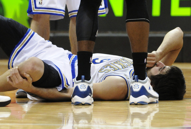 Ricky Rubio yace en el piso agarrándose la rodilla maltratada.