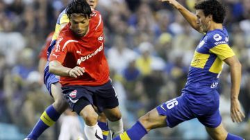 Ernesto 'Tecla' Farías pasa  entre Cristian Erbes (izq.) y Pablo Ledezma, de Boca Juniors. El   delantero, con  tres goles, definió un partido loco.