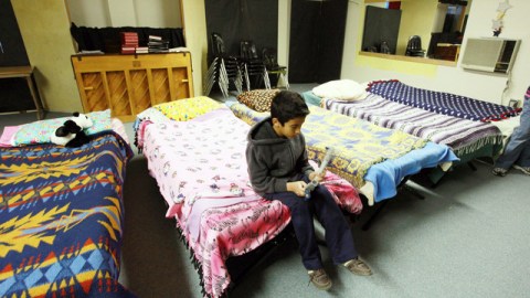 Carlitos, el segundo de los tres hijos de la familia López, juega en el salón de la iglesia donde duerme hace meses.