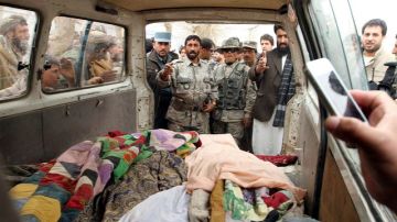 Personas muestran los cadáveres de afganos asesinados presuntamente por un soldado estadounidense, en  Panjwai, ayer.