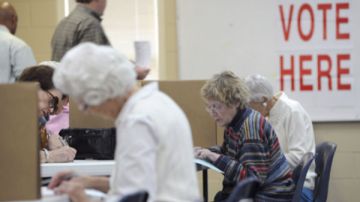Ciudadadanos preparan sus papeletas antes de votar en las primarias, en Montgomery, Alabama.