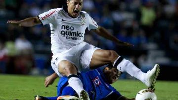 El jugador de Cruz Azul Gerardo Flores (i) despeja el balón ante la marca de Jorge Henrique de Souza (d), de Corinthians.