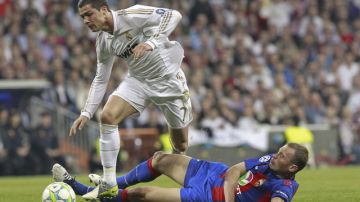 El delantero portugués Cristiano Ronaldo (izq.) aguanta la barrida del  defensa del CSKA de Moscú, Vasili Berezutski, ayer en el Bernabéu.