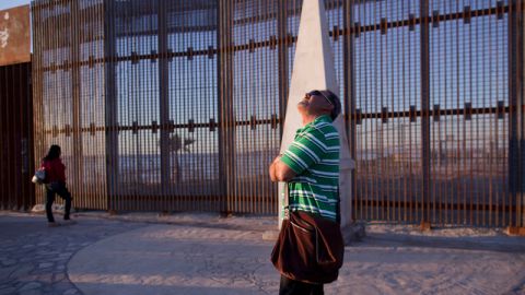 En la foto del 28 de enero de 2012, Agustín Portillo y su esposa Ana  caminan a lo largo de la valla que marca la frontera entre   Estados Unidos y México, en Tijuana.