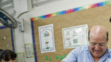 Un voluntario utiliza una luz para ver los dedos del Gobernador Fortuño (d), para confirmar que no ha votado anteriormente, el pasado 18 de marzo.