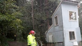 Los bomberos Greg Martin y Tim Williams estudian cómo ayudar en esta situación: Los fuertes vientos y la lluvia provocaron que esta casa se partiera en dos en Camp Meeker, en el condado de Sonoma, en California.