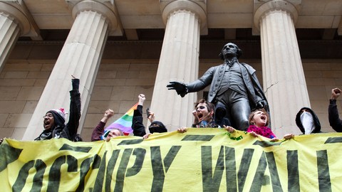 Manifestantes de Occupy  protestando frente a la estatua de George Washington en Wall Street, festejando sus primeros seis meses de nacimiento, en Nueva York.