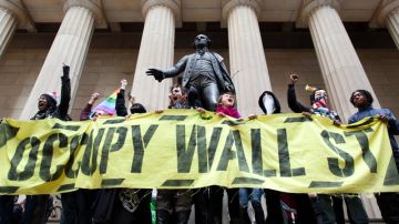 Manifestantes de Occupy  protestando frente a la estatua de George Washington en Wall Street, festejando sus primeros seis meses de nacimiento, en Nueva York.