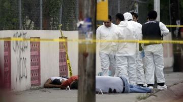 nvestigadores forenses inspeccionan los cuerpos de tres de las seis personas que murieron en el municipio de Apodaca del estado mexicano de Nuevo León.