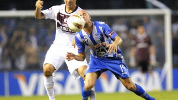 Luciano Figueroa (der.), del Emelec, disputa el balón con Luciano Balbi,   de Lanús, en partido de la Copa Libertadores.