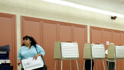 Ciudadanos votan en el colegio electoral situado en la iglesia Santa Cecilia de Arlington Heights, Illinois.