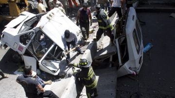 Bomberos buscan víctimas en el interior de una camioneta sobre la que cayó parte de un puente en la capital.