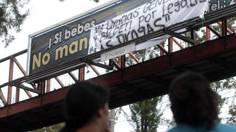 Residentes del Departamento de El Petén, leen el mensaje de advertencia colocado por el cartel frente a una escuela.