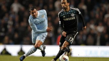 Carlos Tévez (izq.), del Manchester City, disputa el balón con José Bosingwa, del Chelsea,  en el partido de ayer en la Liga Premier.