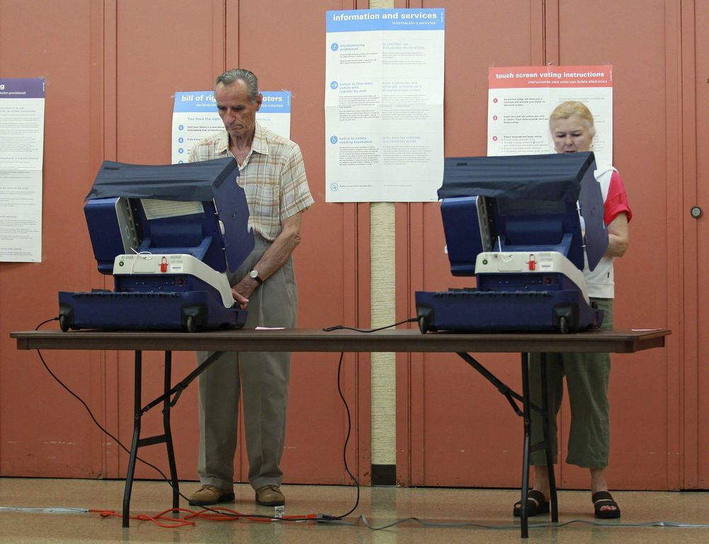 Ciudadanos votan en el colegio electoral situado en la iglesia Santa Cecilia de Arlington Heights, Illinois, Estados Unidos, el martes, 20 de marzo de 2012.