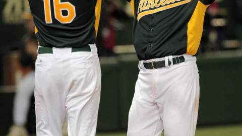 Kurt Suzuki (der.) celebra con Alex Liddi después de su jornón de dos carreras para los Atléticos ante los Gigantes Yomiuri.