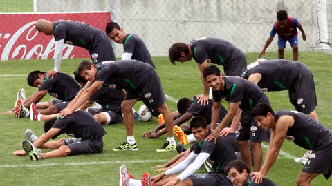 Jugadores del Monterrey realizan ejercicios de estiramiento durante  la práctica de ayer en la cancha de El Barrial.
