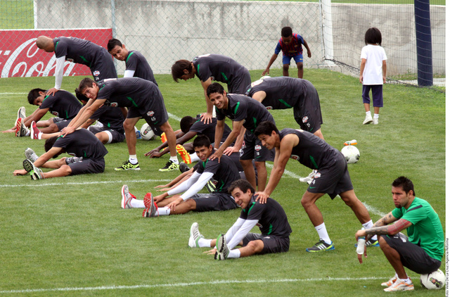 Jugadores del Monterrey realizan ejercicios de estiramiento durante  la práctica de ayer en la cancha de El Barrial.