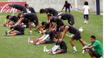Jugadores del Monterrey realizan ejercicios de estiramiento durante  la práctica de ayer en la cancha de El Barrial.