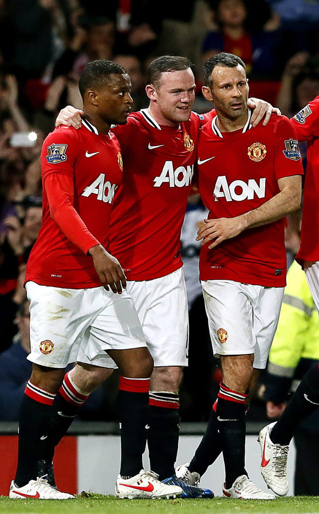 Wayne Rooney (cent.) es felicitado por  Patrice Evra (izq.) y Ryan Giggs.