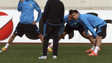 Cristiano Ronaldo y  Fabio Coentrao atienden a las indicaciones del técnico  José Mourinho en la práctica del equipo en Nicosia.