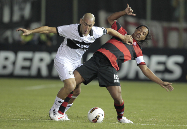 Sergio Orteman (izq.), de Olimpia, desarma a Ronaldinho en un trámite del partido disputado anoche en el marco de la Copa Libertadores.