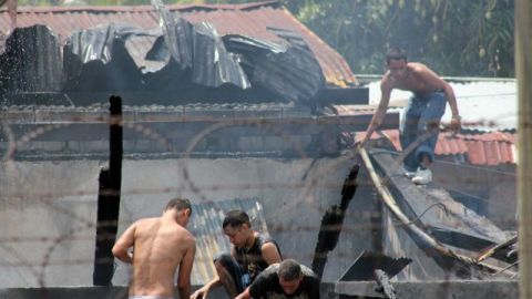 Reclusos hondureños lanzan desde el tejado agua para poder sofocar el incendio en el interior del Centro Penal de San Pedro Sula, al norte de Honduras.