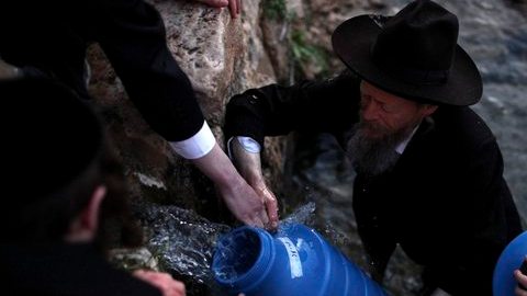 Judíos ultraortodoxos cogen agua de una montaña para elaborar pan ázimo durante los preparativos de la Pascua Judía.