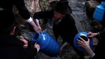 Judíos ultraortodoxos cogen agua de una montaña para elaborar pan ázimo durante los preparativos de la Pascua Judía.