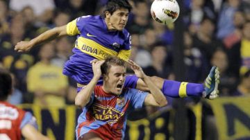 El jugador de Boca Juniors, Facundo Roncaglia, (arriba), disputa el balón con Juan Pablo Caffa del Arsenal en el juego de ayer.